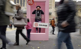 Un homme pose dans une boîte géante, à Lausanne, pour protester contre les conditions de travail en vigueur dans les usines Mattel.
