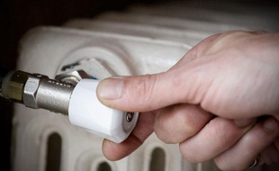 Un homme règle son chauffage à gaz en fonte. Illustration gaz, chauffage.