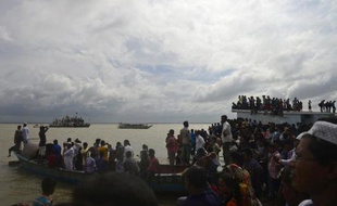 Des passants aux côtés des rescapés du naufrage d'un ferry sur le fleuve Padma, au sud de Dacca, le 4 août 2014
