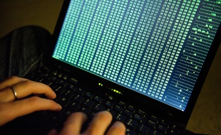 Paris le 15 avril 2012. Illustration hacker pirate informatique. Ligne s de code. Programme. Ordinateur portable.