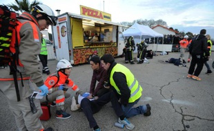 Des services de secours prennent en charge un patient, lors de la simulation d'attaque terroriste dans une "fans zone", le 17 mars 2016