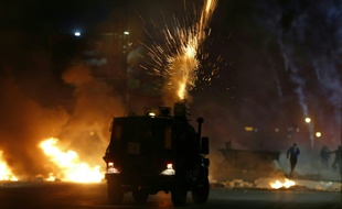 Des soldats israéliens tirent des gaz lacrymogènes sur des manifestants palestiniens dans une colonie juive près de Ramallah, en Cisjordanie, le 11 mai 2021.