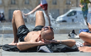 Un homme tentant de se rafraîchir au bord d'une fontaine