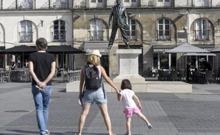 Des touristes devant la statue « Eloge du pas de côté » place du Bouffay à Nantes.