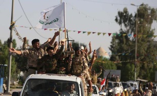 Des membres des brigades Al-Abbas, constituées pour défendre Kerbala contre les insurgés, défilent le 26 juin 2014