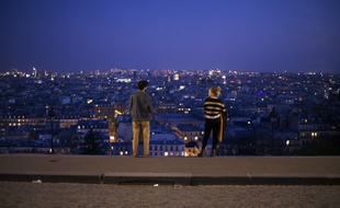 Ambiance dans le quartier de Montmartre. Un couple se tenant a distance en haut des marches aboutissant au Sacre-Coeur, le 18 mars 2020.
