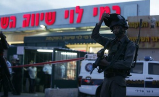 Les forces de sécurité israéleinnes se tiennent devant le supermarché Rami Levi où a eu lieu une attaque au couteau par des Palestiniens, le 18 février 2016, à Shaar Binyamin, près de Ramallah