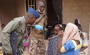 Photo fournie par l'armée nigériane le 30 avril 2015 prise dans un lieu non divulgué de l'Etat de Borno montrant un militaire discutant avec des jeunes filles libérées lors d'une opération contre le groupe islamiste Boko Haram