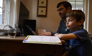 Un enfant qui suit l'école à la maison en mars 2020.