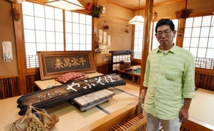 Satoru Yamauchi pose le 16 juillet 2015 à Naraha à l'intérieur de son restaurant, qu'il a dû abandonner pour échapper aux retombées radioactives de l'accident de la centrale de Fuhushima