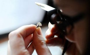 Expertise d'une bague avec un diamant solitaire. Avec 30 % de hausse d'activite depuis janvier, le Credit Municipal de Paris, etabissement public, municipal et social, cree en 1777, accueille environ 500 personnes par jour, a la recherche de prets sur gage. 10 % des francais n'ayant pas acces aux prets bancaires, ils peuvent, contre des biens deposes en gage (80% de bijoux), se faire preter de l'argent. Au bout d'un an, les 7% de biens non recuperes, sont vendus aux encheres. Paris, FRANCE - 14/10/2008