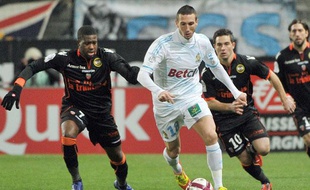 Morgan AMalfitano à la lutte avec les Lorientais Arnold Mvuemba et Mathieu Coutadeur pendant le match Marseille-Lorient de la 18e journée del Ligue 1 le 17 décembre 2011.