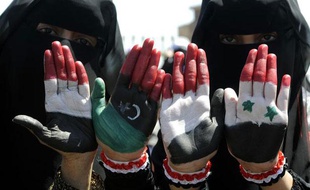 Des manifestants montrent leurs mains aux couleurs de la Libye pré-Kadhafi, la Syrie et le Yémen, vendredi 21 octobre, lors d'une manifestation à Sanaa, au Yémen.