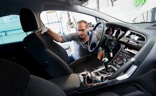 Un technicien d'un centre automobile inspecte un véhicule.
