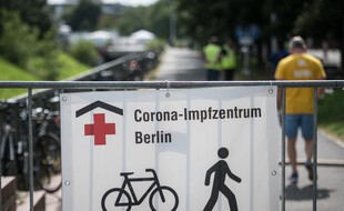 Une banderole montre le chemin vers un centre de vaccination à Berlin alors que les gens arrivent pour se faire vacciner contre le coronavirus, le 30 juillet 2021.