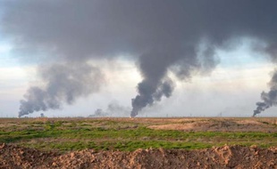 De la fumée s'échappe d'un champ pétrolier près de Kirkouk, suite à une opération des forces kurdes irakiennes contre les jihadistes de l'EI le 31 janvier 2015