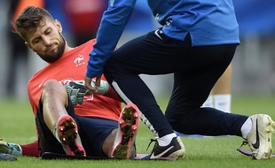 France's goalkeeper Benoit Costil (L) grimaces after injury during a training session, on September 5, 2015 at the stadium in Bordeaux, two days before the Euro 2016 friendly football match between France and Serbia on September 7. AFP PHOTO / FRANCK FIFE