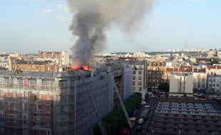 Des pompiers sur une échelle pour tenter d'éteindre l'incendie qui s'est déclaré dans un immeuble résidentiel d'Aubervilliers, en banlieue parisienne, le 7 juin 2014