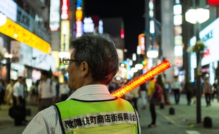 Un membre de la patrouille chargée d'informer les clients des risques d'escroquerie dans le quartier de Kabukicho à Tokyo, le 24 juin 2015.