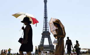Des touristes se protègent du soleil à Paris.