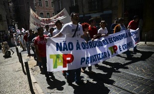 Des manifestants brandissent une bannière "Non à la destruction de l'économie nationale" lors d'une marche à Lisbonne contre les privatisations dans le secteur des transports, le 21 mai 2015