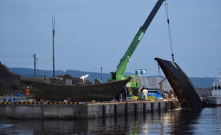 Des bateaux nords coréens qui se sont échoués sur les côtes japonaises, sont sortis de l'eau par une grue, le 21 novembre 2015.