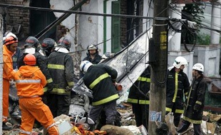Les secours s'activent autour de l'épave de l'avion qui s'est écrasé dimanche sur une maison, dans le quartier de Sao Paulo