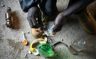 Un toxicomane prépare son injection, dans un bâtiment abandonné de la périphérie de Johannesbourg, en Afrique du Sud, le 17 juillet 2015