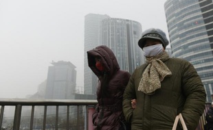Des femmes traversent un pont à Pékin le 26 décembre 2015