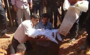Le père du petit Aylan Kurdi (c) tient entre ses bras la dépouille de son fils avant son enterrement à Kobané en Syrie, le 4 septembre 2015