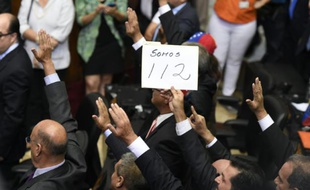 Un député de l'opposition brandit une pancarte "Nous sommes 112" pendant la cérémonie d'investiture du Parlement, à Caracas le 5 janvier 2016