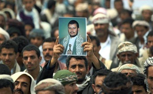 Un chiite brandit la photographie du chef rebelle d'Ansaruallah, Abdel Malek al-Houthi, qui a ordonné à ses partisans de marcher sur Sanaa pour renverser le gouvernement le 20 août 2014 à Hamdan, à 10 km de l'aéroport international de Sanaa