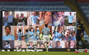 A l'Etihad Stadium de Manchester City, des écrans diffusent des images de supporters en train de regarder le match depuis leur salon.