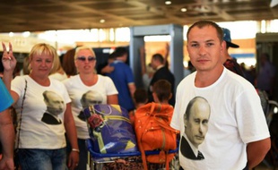 Le portrait du président Vladimir Poutine sur des T-shirts portés par des touristes russes, à l'aéroport de Charm-el-Cheikh, le 6 novembre 2015 après le crash d'un avion de ligne russe en Egypte