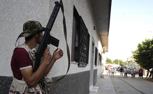 Un insurgé libyen patrouille dans les rues de Tripoli, le 22 août 2011.