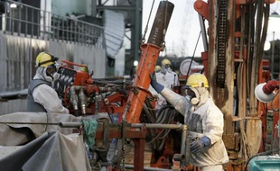 Des ouvriers préparent des tuyaux pour la construction d'un "mur de glace" censé réduire la quantité deau contaminée séchappant dans locéan, le 9 juillet 2014 à la centrale nucléaire de Fukushima, au Japon