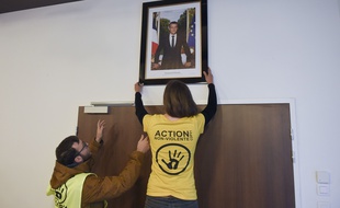 Des militants écologistes décrochent un portrait d'Emmanuel Macron dans une mairie en mars 2019. Ici à Saint-Sébastien-sur-Loire, en Loire-Atlantique.