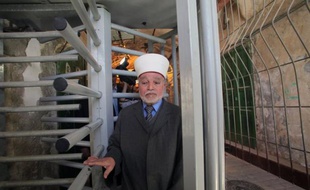 The Mufti of Jerusalem and Palestine, Sheikh Mohammed Hussein passes through an iron gate as he crosses an Israeli checkpoint in the occupied West Bank city of Hebron to go to the Ibrahimi Mosque or the Tomb of the Patriarch on March 25, 2013. The Ibrahimi Mosque and the Tomb of the Patriarch will be closed to Muslims on March 27 and 28 due to the Jewish holiday of Pesach (Passover). AFP PHOTO/HAZEM BADER