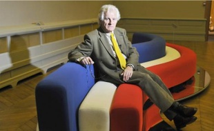 Pierre Paulin en 2008, assis sur sur un canapé créé par lui-même en 1969.