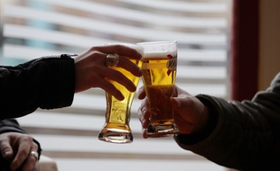 Deux hommes en train de trinquer dans un bar (image d'illustration).