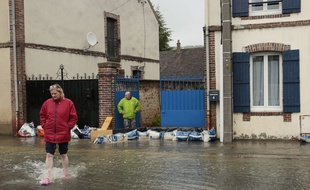 Face à la montée des eaux, les habitants tentent de protéger leur habitation.
