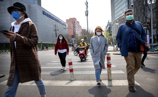 Des passants dans la rue à Pékin, le 7 avril 2020.