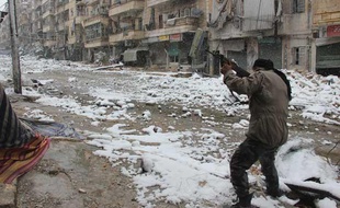 Alep, le 11 décembre 2013, un opposant au régime syrien pointe son arme vers les balcons enneigés de la ville.