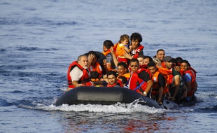 Des migrants à bord d'un canot pneumatique en provenance de la Turquie, approchent des côtes de l'île grecque de Lesbos, le 9 septembre 2015.