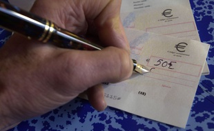 Une personne signe un chèque (Illustration).