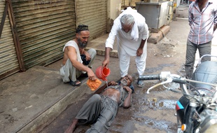 Karachi, le 22 juin 2015. Des Pakistanais portent secours à un homme épuisé par la chaleur.
