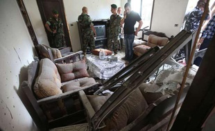 Des soldats libanais inspectent un appartement touché par une roquette, dans le sud de Beyrouth, le 26 mai 2013.