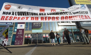 Des syndicalistes manifestent contre l'ouverture dominicale du supermarché Carrefour Grand Maine à Angers.