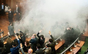 Des membres du parlement kosovare tentent de poursuivre les débats, le 19 février 2016 à Pristina, en dépit du gaz lacrymogène lancé par l'opposition qui réclame la démission du gouvernement