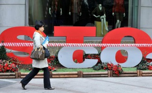 Une femme passe devant un slogan "Stop CO2" à Séoul le 9 décembre 2009